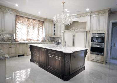 Elegant kitchen with cream cabinets, granite countertops, and a chandelier.