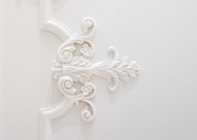 Elegant white wall panel with intricate floral molding design.